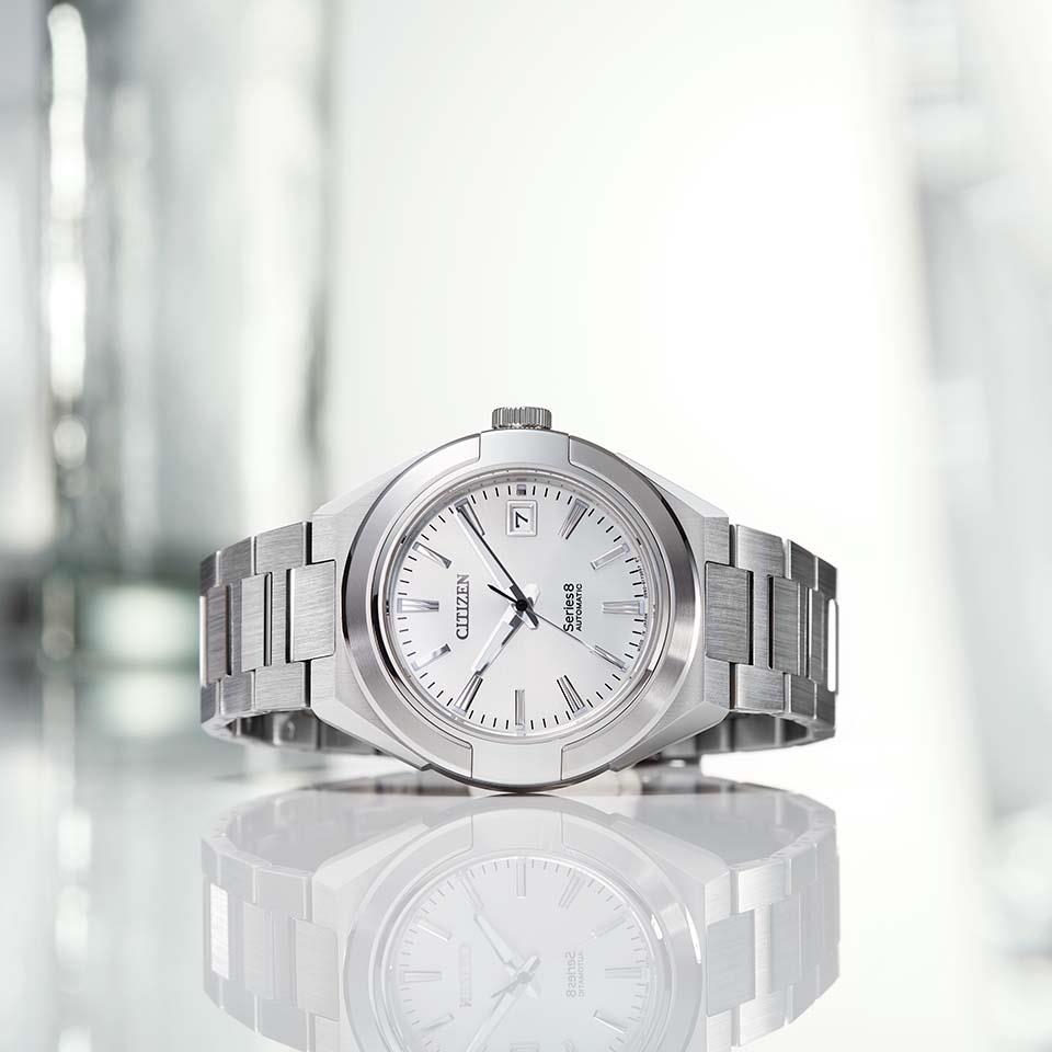 Citizen Series Eight NA1000-88A Mechanical Men's Watch, Stainless Steel Case, White Dial, Stainless Triple Link Band,Image cut on the table.